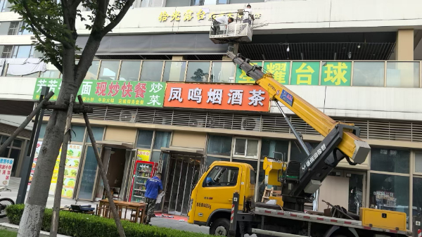 18米登高车载人安装广告牌施工现场